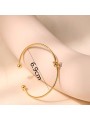 Bracciale rigido in metallo con nodo centrale e placcatura in oro